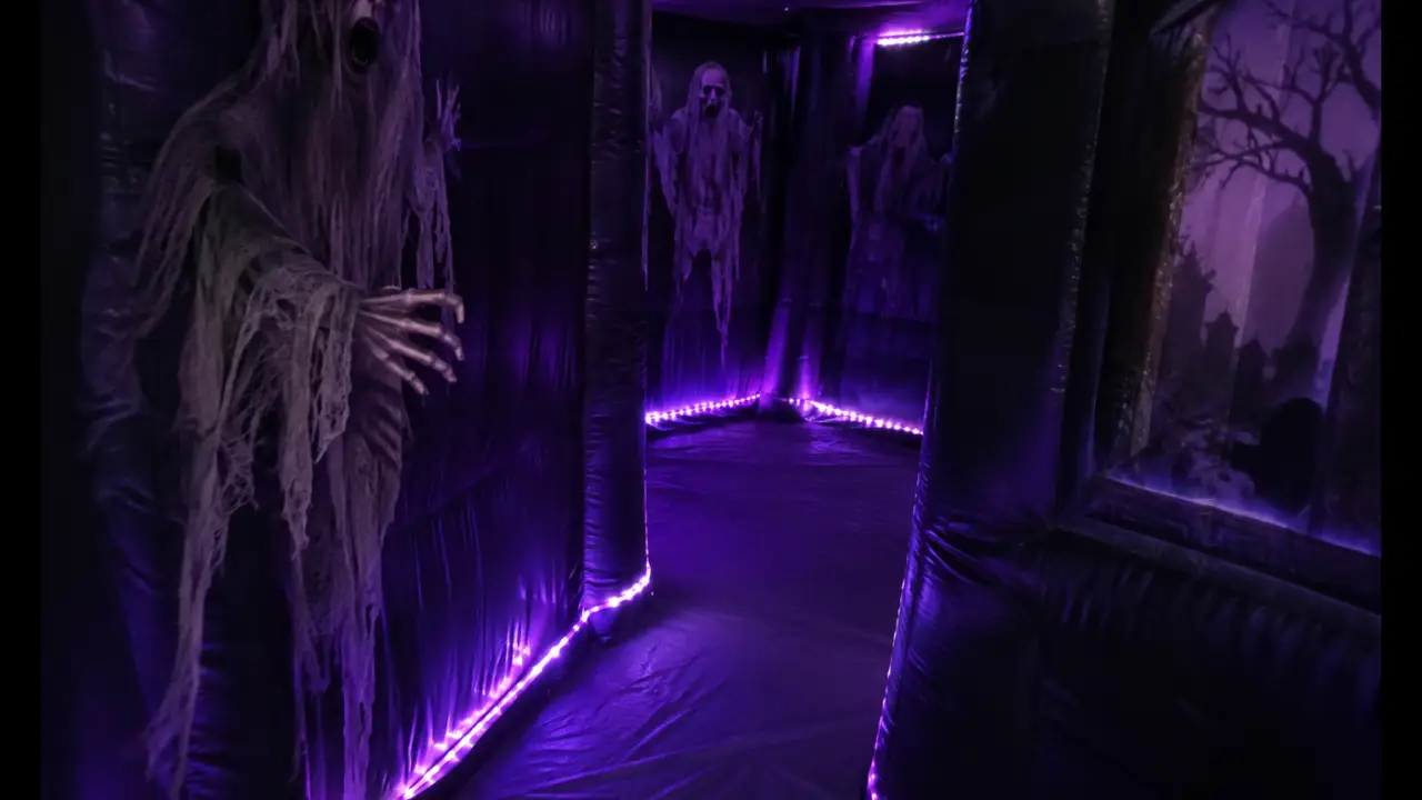 Intérieur sombre de labyrinthe de maison hantée gonflable avec éclairage LED violet